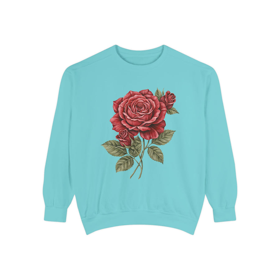 Light green sweatshirt printed with a single large red rose in botanical style, its layered petals opening above two smaller buds on a slender stem with broad sage-toned leaves.