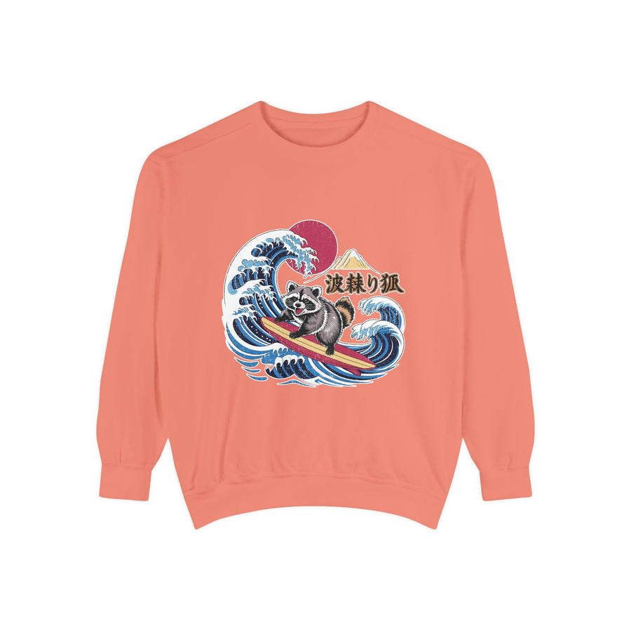 Blue jean sweatshirt folded flat with the cuffs rolled back, printed with a raccoon surfing a breaking Japanese wave below a red sun and a mountain, with Japanese characters set beside it.