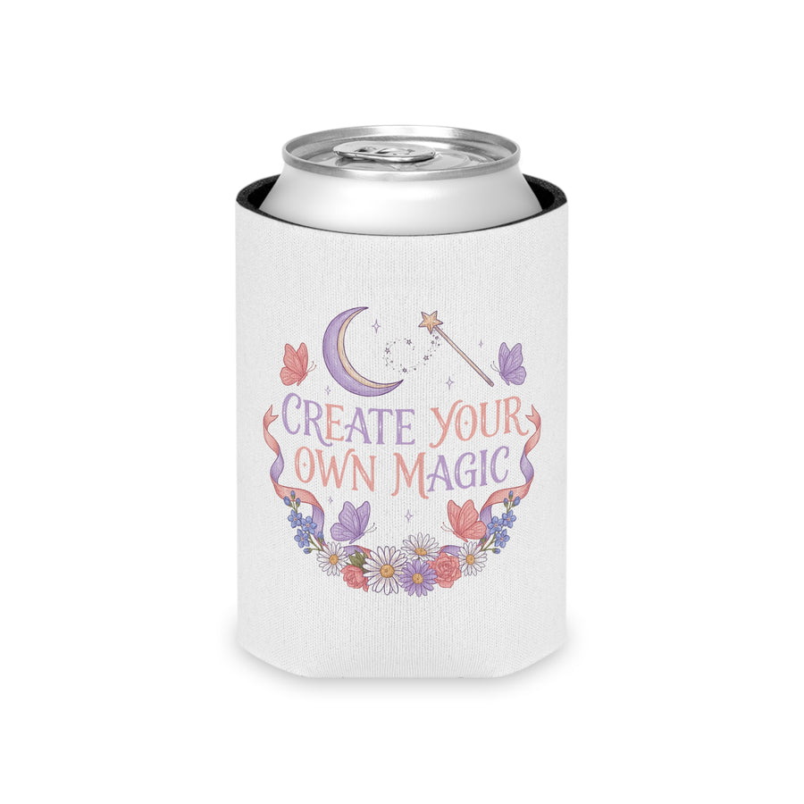 A white can cooler on a drink can, printed with "CREATE YOUR OWN MAGIC" in lilac and coral lettering under a crescent moon and a star wand, framed by butterflies, ribbons and flowers.