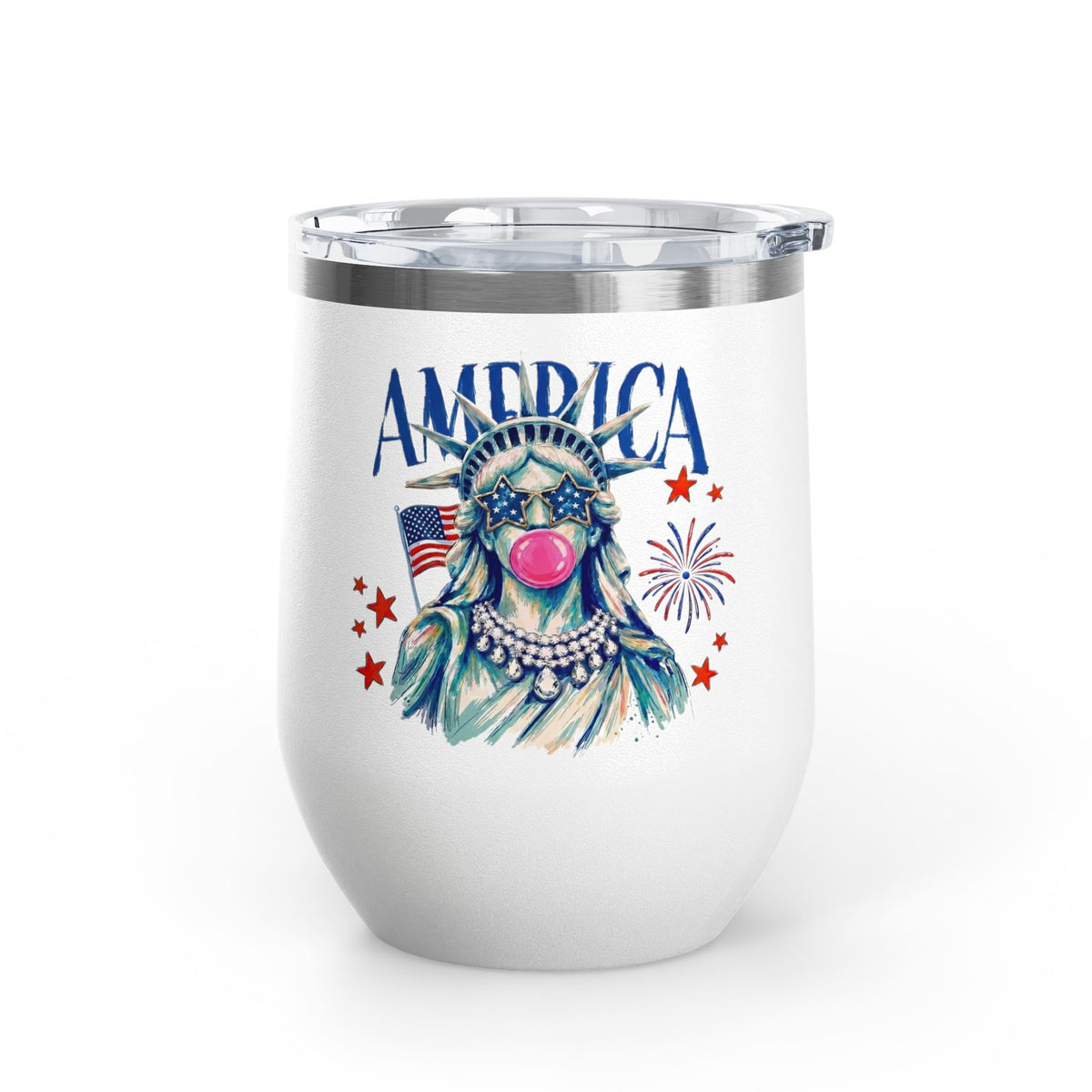 A white stainless steel wine tumbler with a clear push-on lid, printed with an illustrated Statue of Liberty wearing star sunglasses and a pearl necklace, an American flag, fireworks, and the word 'AMERICA,' on a plain white background.
