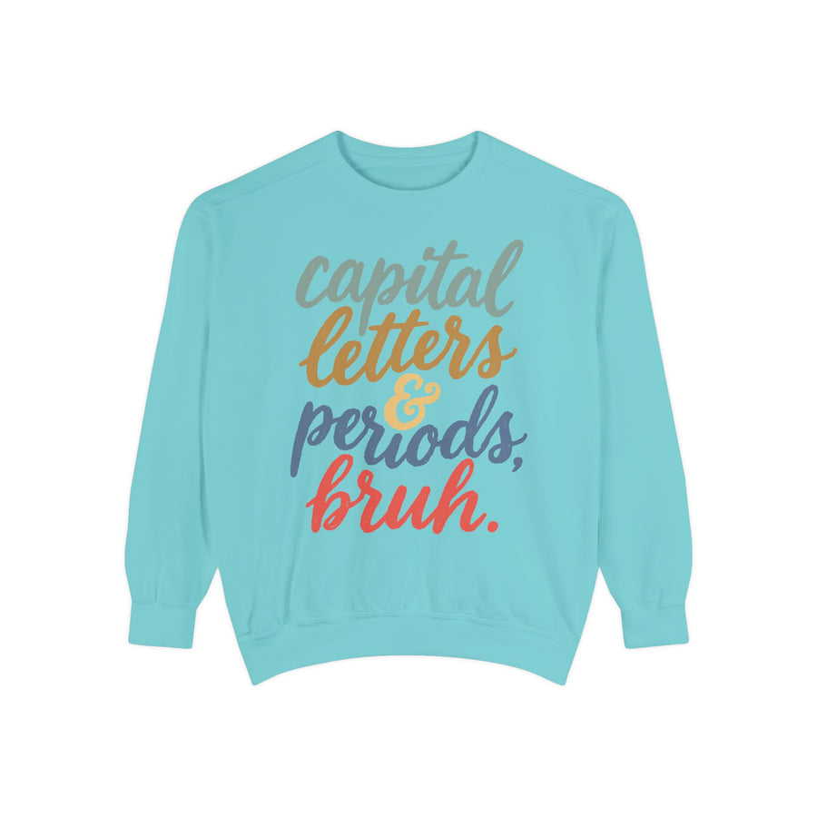 White sweatshirt printed with the words capital letters and periods, bruh in flowing script, each line set in its own colour: sage, then gold, then slate blue, then coral.