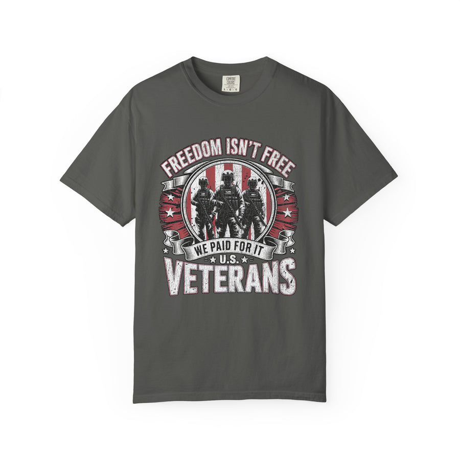 A woman wearing a dark gray t-shirt printed with Freedom Isn't Free above three soldiers on a red flag badge, with We Paid For It and U.S. Veterans below.