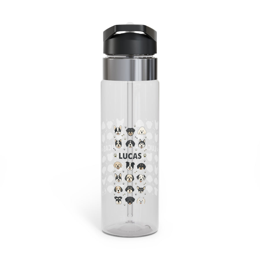 A clear Tritan water bottle with a black screw-on lid and straw, printed with colorful puppy graphics and a name, styled with kids school supplies.