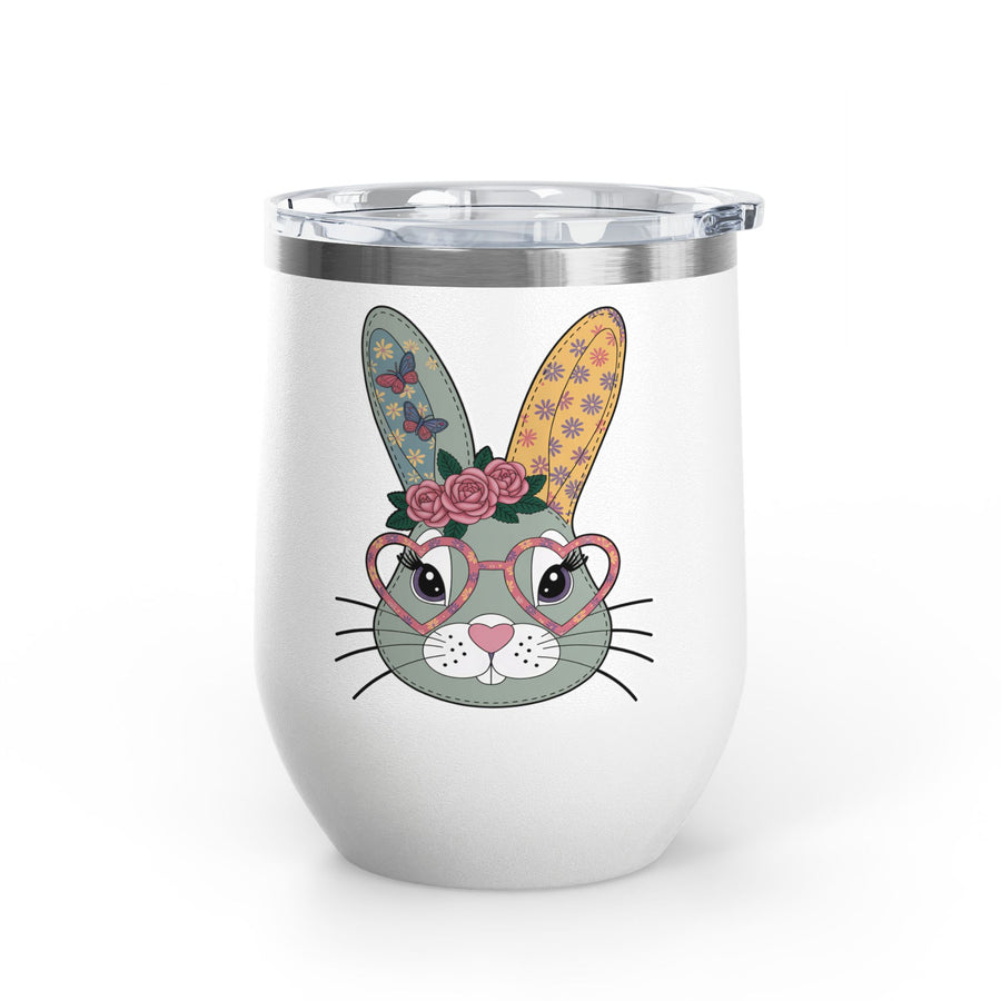 A white stainless steel stemless wine tumbler with a clear push-on lid, printed with a cute gray-green bunny face wearing pink heart-shaped glasses and a crown of pink roses, with butterfly and flower patterned ears.