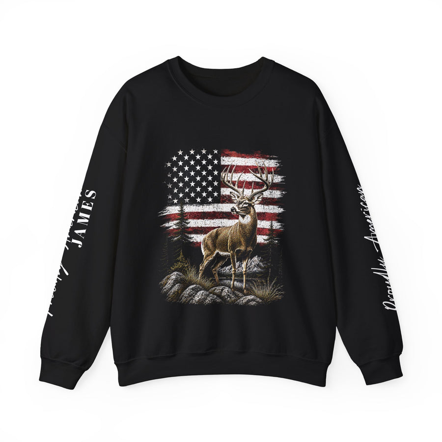 A woman wearing a black crewneck sweatshirt printed with a buck standing before a weathered American flag, with Proudly American and a sample name, James, down both sleeves.