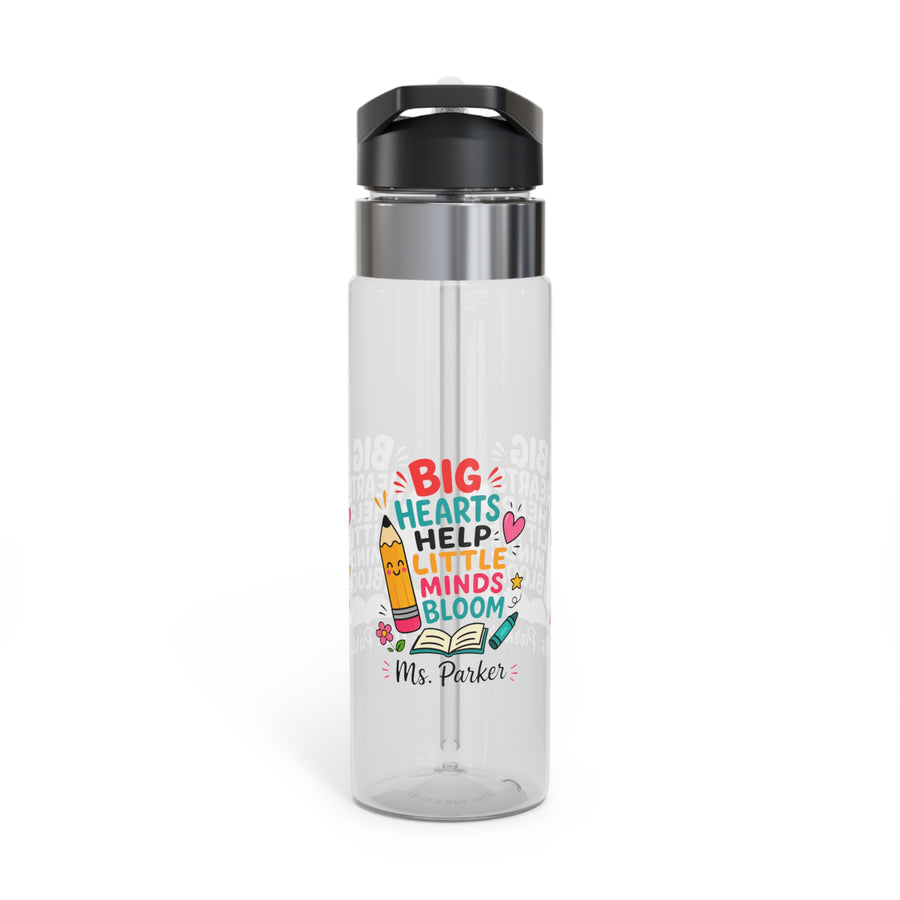 A clear water bottle with a black lid and straw, printed with colorful pencils, notebooks and school supplies around the name "Ms. Harper" in black text.