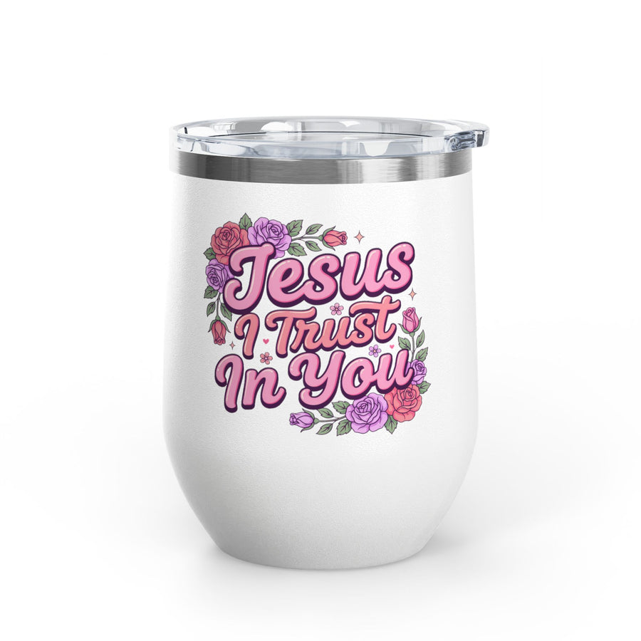 A white stainless steel stemless wine tumbler with a clear push-on lid, printed with "Jesus I Trust In You" in pink retro script framed by pink, red and purple roses and greenery.
