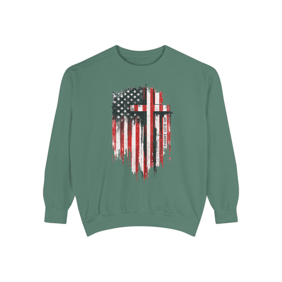 A gray crewneck sweatshirt printed with a distressed American flag with two black crosses and the words God Bless America.