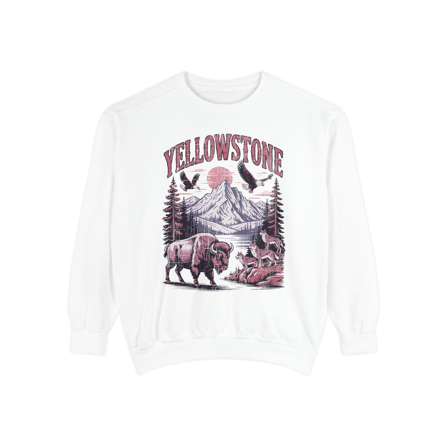 A white crewneck sweatshirt printed with Yellowstone above a mountain scene with a bison, wolves and eagles under a red sun.