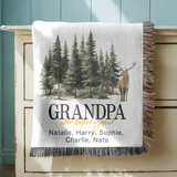 White fringed woven blanket printed with a watercolour pine forest and a standing antlered stag, reading Grandpa above we love you in gold and five names in a line beneath.