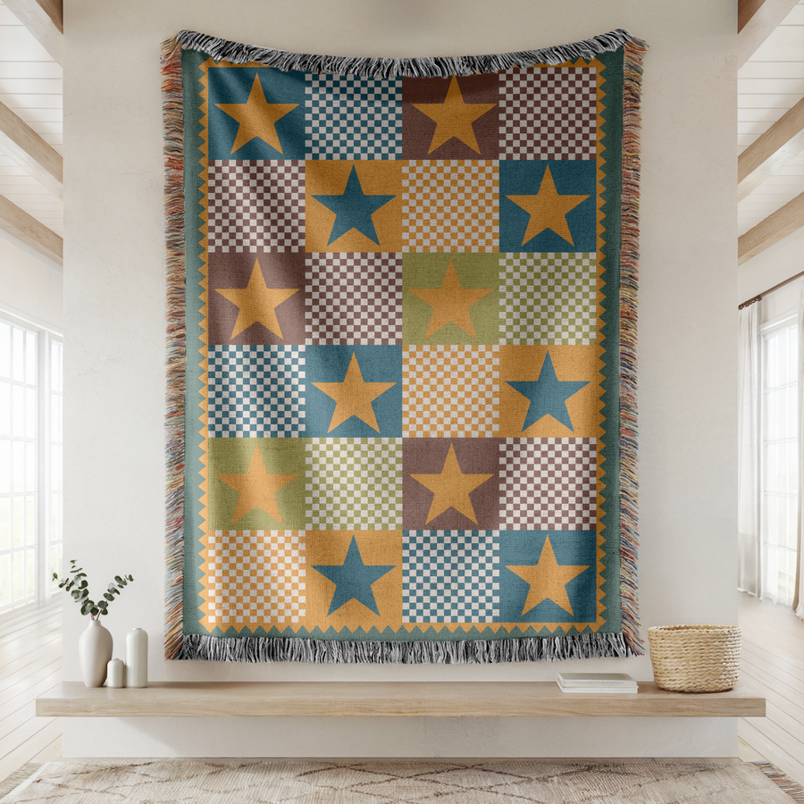 Fringed woven blanket pieced from checkerboard squares in teal, ochre, brown and sage, each square carrying a single large five-pointed star, set inside a gold zigzag border.