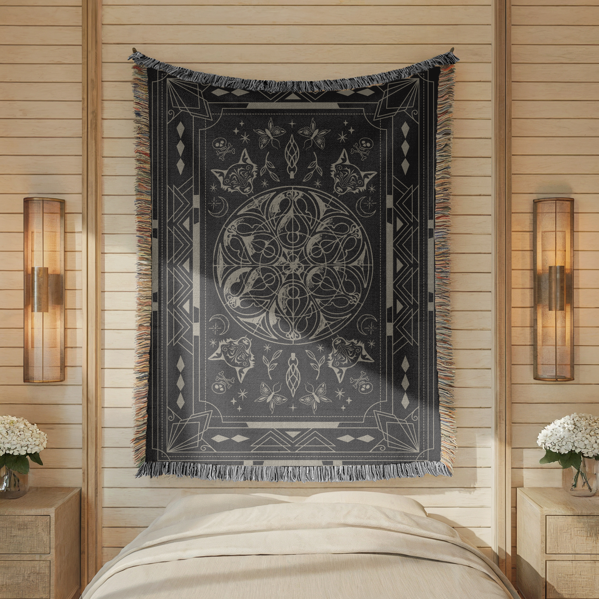 Charcoal fringed woven blanket printed in cream with an ornate bordered panel, a central knot of coiled snakes, wolf heads at the corners, moths, roses and crescent moons.