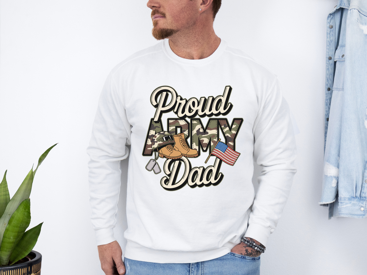 A white crewneck sweatshirt printed with Proud Army Dad in script and camouflage lettering with combat boots, dog tags and an American flag.
