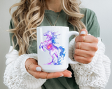 White mug printed with a rearing horse painted in swirling purple, pink and blue watercolour, its body scattered with stars and a glowing point of light burning at its centre.