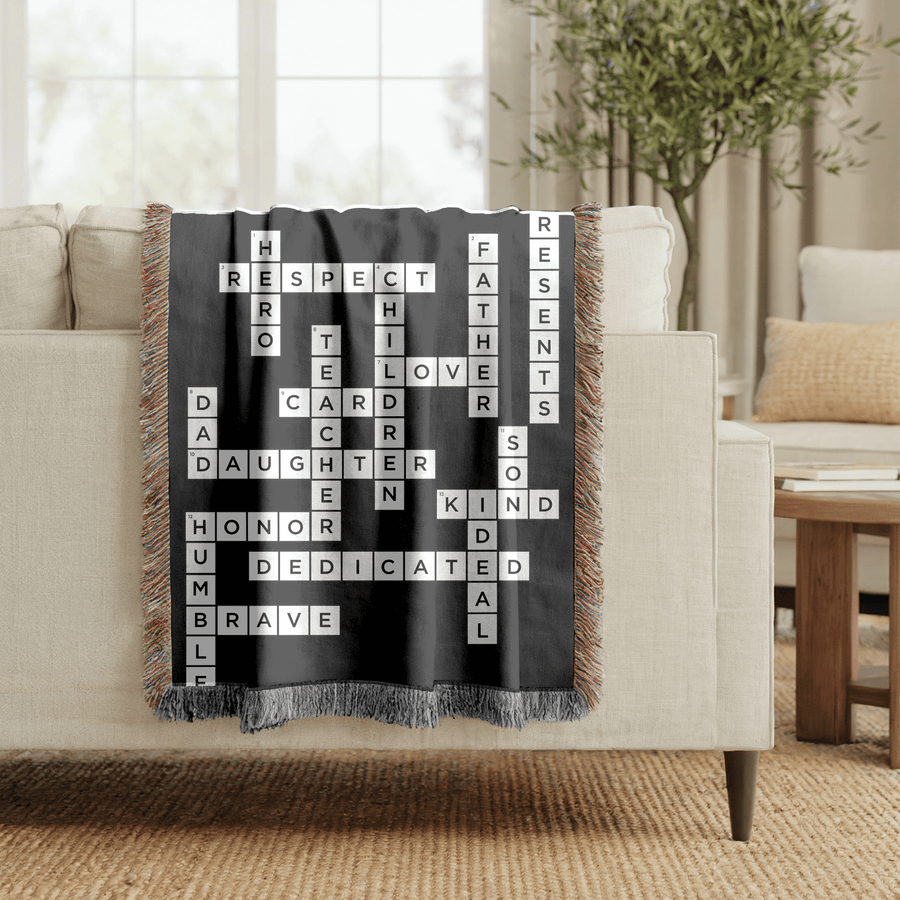 Black fringed woven blanket printed as a crossword of white letter tiles spelling out Respect, Hero, Father, Teacher, Children, Love, Daughter, Son, Kind, Honor and Brave.