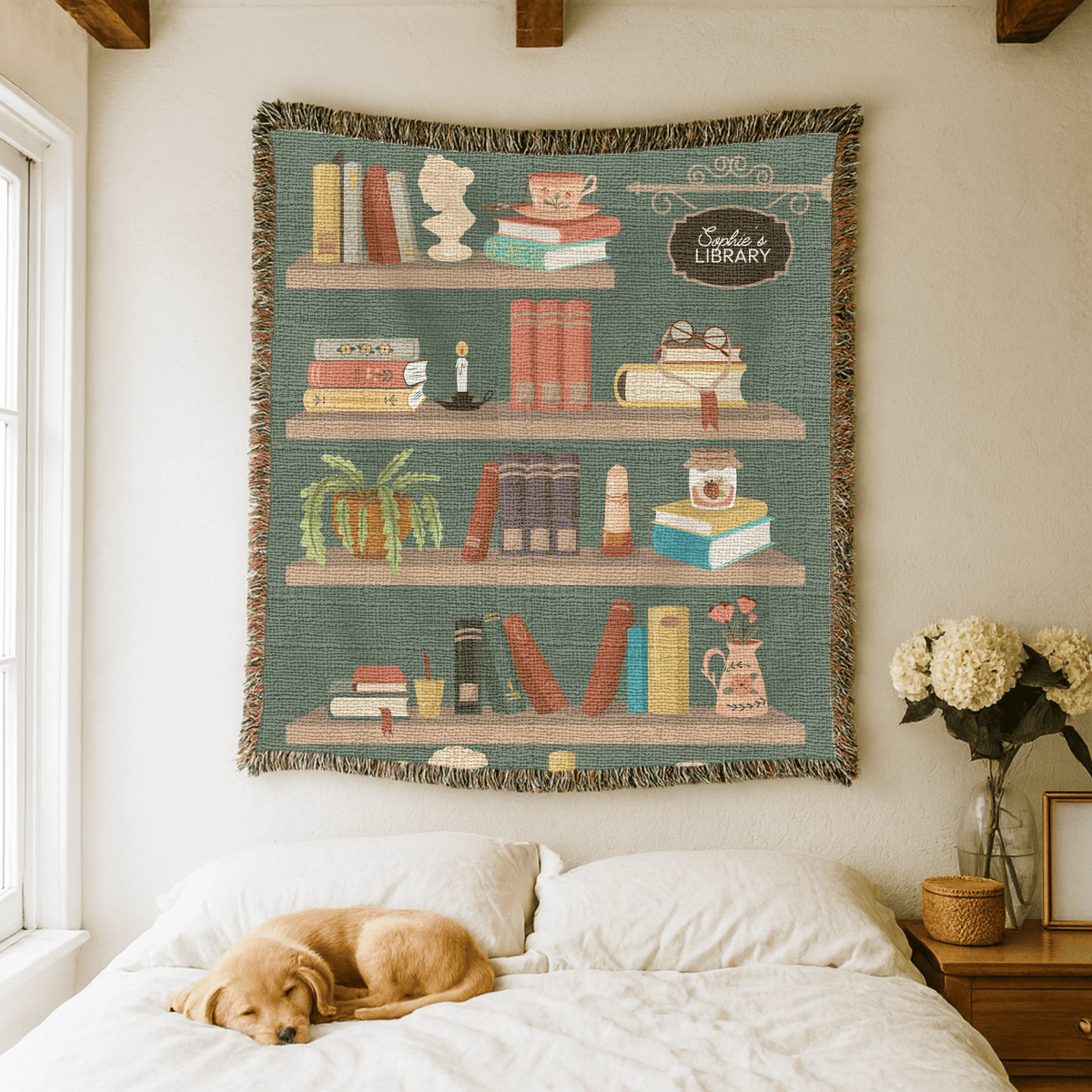 Teal fringed woven blanket printed as four bookshelves holding books, a teacup, a cat, a trailing plant, a candle and a vase of poppies, with a sign reading Sadie's Library.
