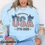 Chambray sweatshirt printed with USA in tall letters filled with the American flag, topped by two polka-dot bows, above the dates 1776 to 2026 and headed 250th Anniversary.