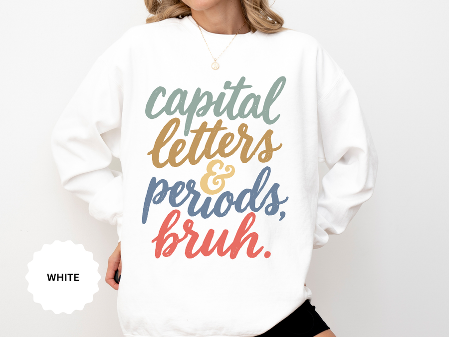 White sweatshirt printed with the words capital letters and periods, bruh in flowing script, each line set in its own colour: sage, then gold, then slate blue, then coral.