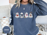 A denim-blue crewneck sweatshirt printed with four little ghosts reading books, one in a witch hat.
