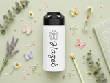 White water bottle with a black lid, printed with a simple line-drawn butterfly above the name Hazel, both in black and set reading downwards along the length of the bottle.