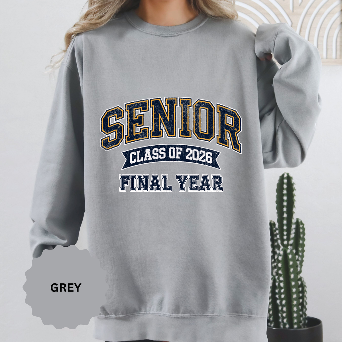A gray crewneck sweatshirt printed with SENIOR in navy and gold varsity letters above Class of 2026 and Final Year.