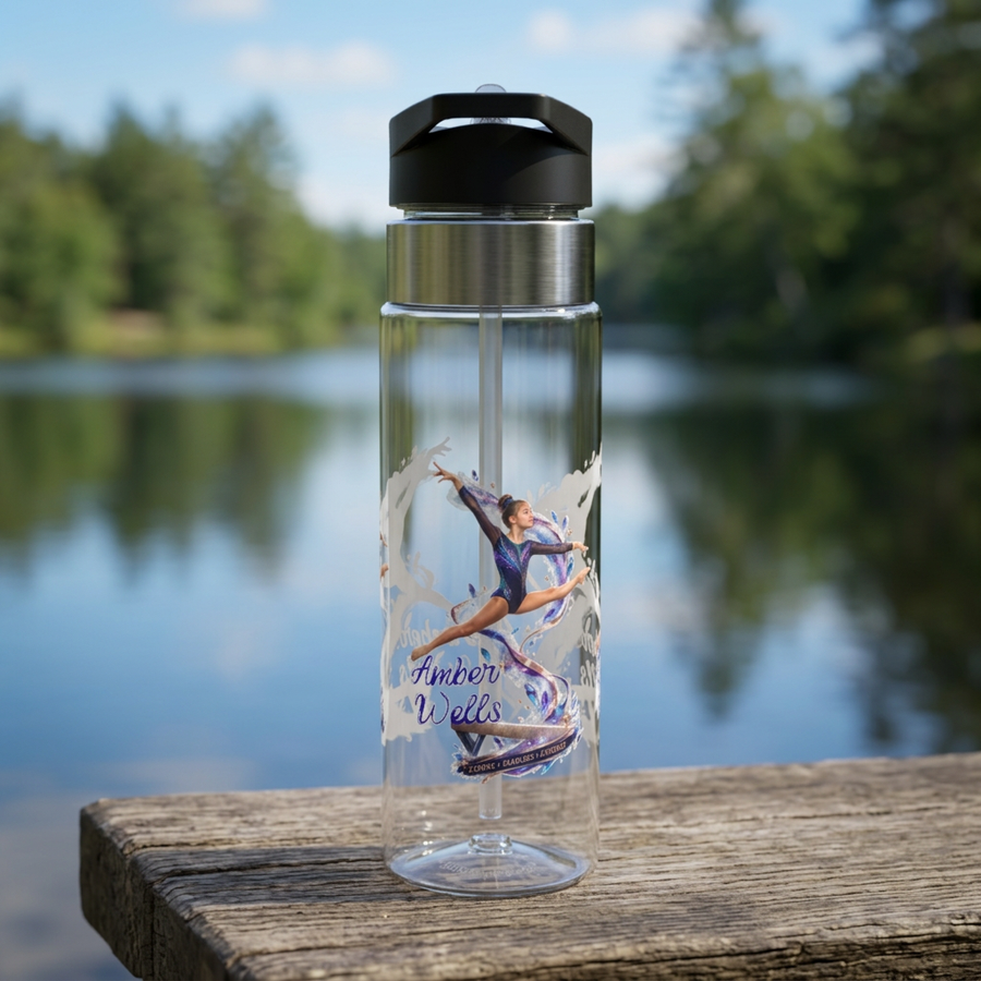 Clear plastic water bottle with a black flip lid and a straw, printed with a gymnast in a purple leotard leaping through a flowing ribbon, with the name Amber Wells in navy script below.