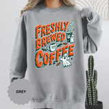 A gray crewneck sweatshirt printed with Freshly Brewed Coffee in orange lettering with ghosts, a coffee cup and bats.