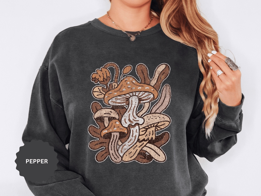 A dark gray crewneck sweatshirt printed with a retro cluster of brown and tan mushrooms among leaves.