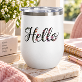 A white stainless steel wine tumbler with a clear push-on lid, printed with the word "Hello" in black script decorated with small pink and purple flowers, on a marble surface.