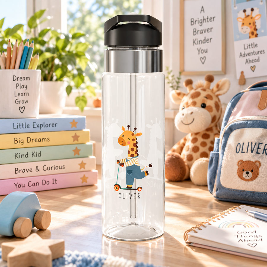 A clear water bottle with a black lid and straw, printed with a cartoon giraffe riding a scooter and the name "Oliver" in black text, on a desk with toys.