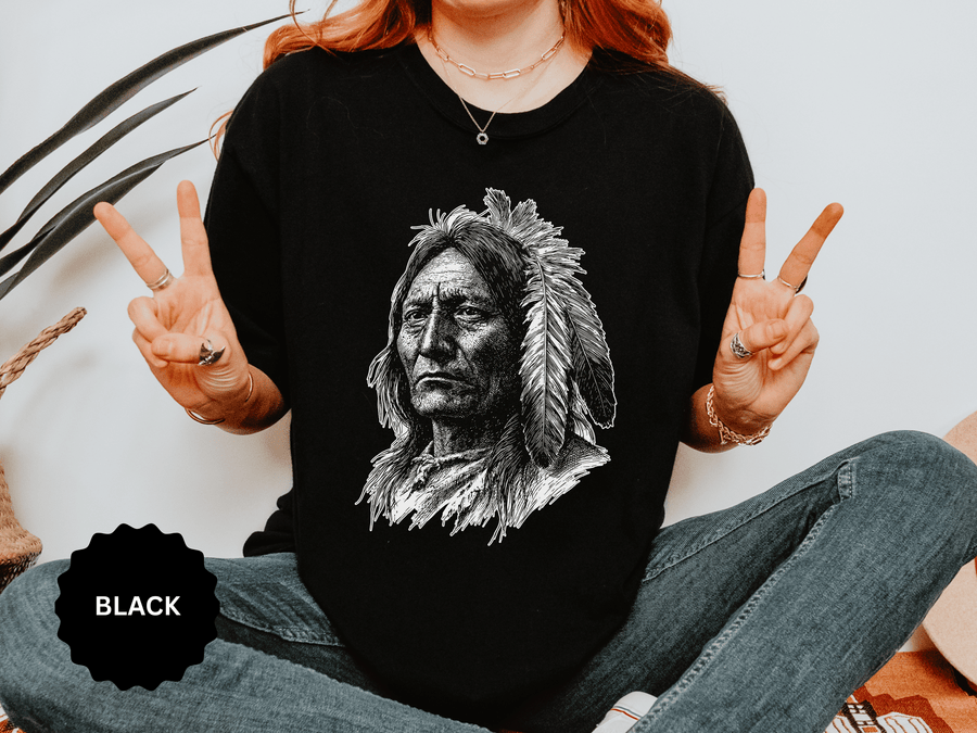 A black T-shirt printed with a detailed black-and-white portrait of a Native American elder in a feathered headdress.