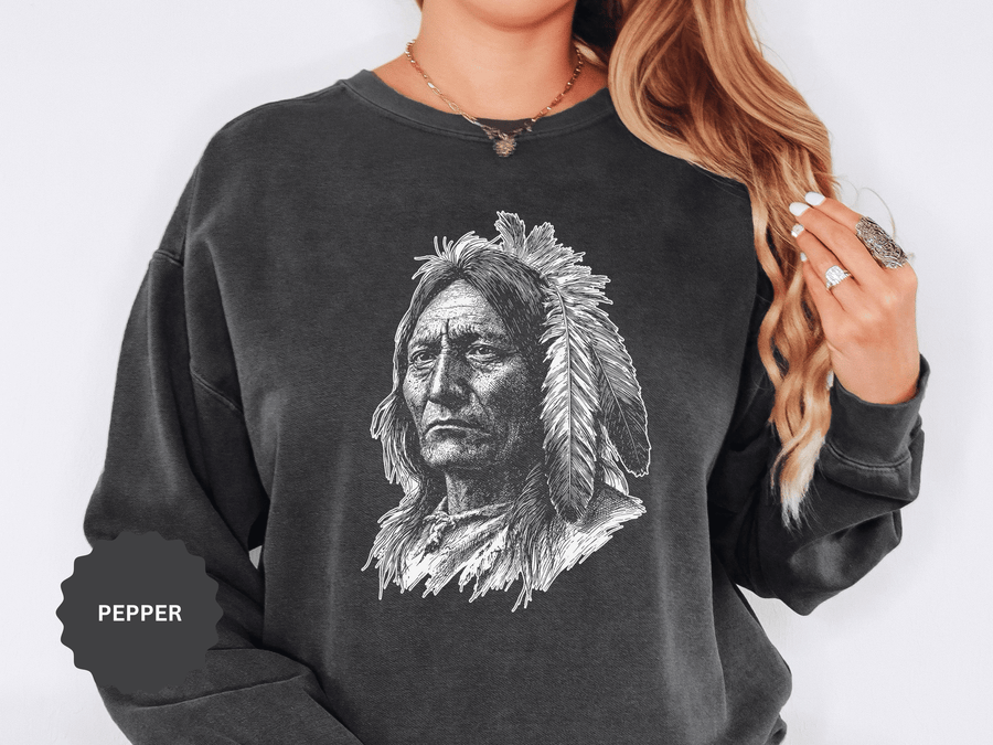 A dark gray crewneck sweatshirt printed with a detailed black-and-white portrait of a Native American elder in a feathered headdress.
