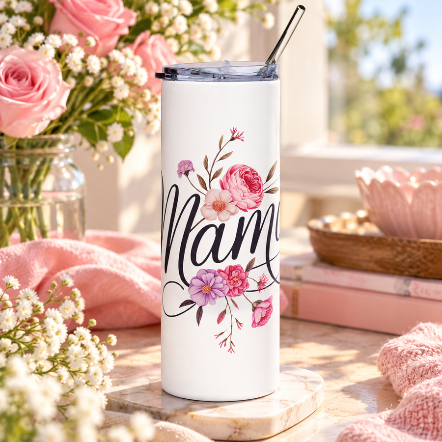 A white stainless steel skinny tumbler with a clear lid and metal straw, printed with "Mama" in black script with pink and purple flowers woven through the lettering.