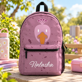 A backpack with a black top handle, front zip pocket and mesh side pocket, speckled pink with a cartoon pink duck face with an orange beak and the sample name "Natasha" in white script on the pocket.