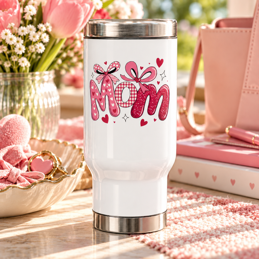 A white stainless steel travel mug with a silver lid and base, printed with "Mom" in pink heart-print, gingham and glitter letters topped with pink bows and small hearts.