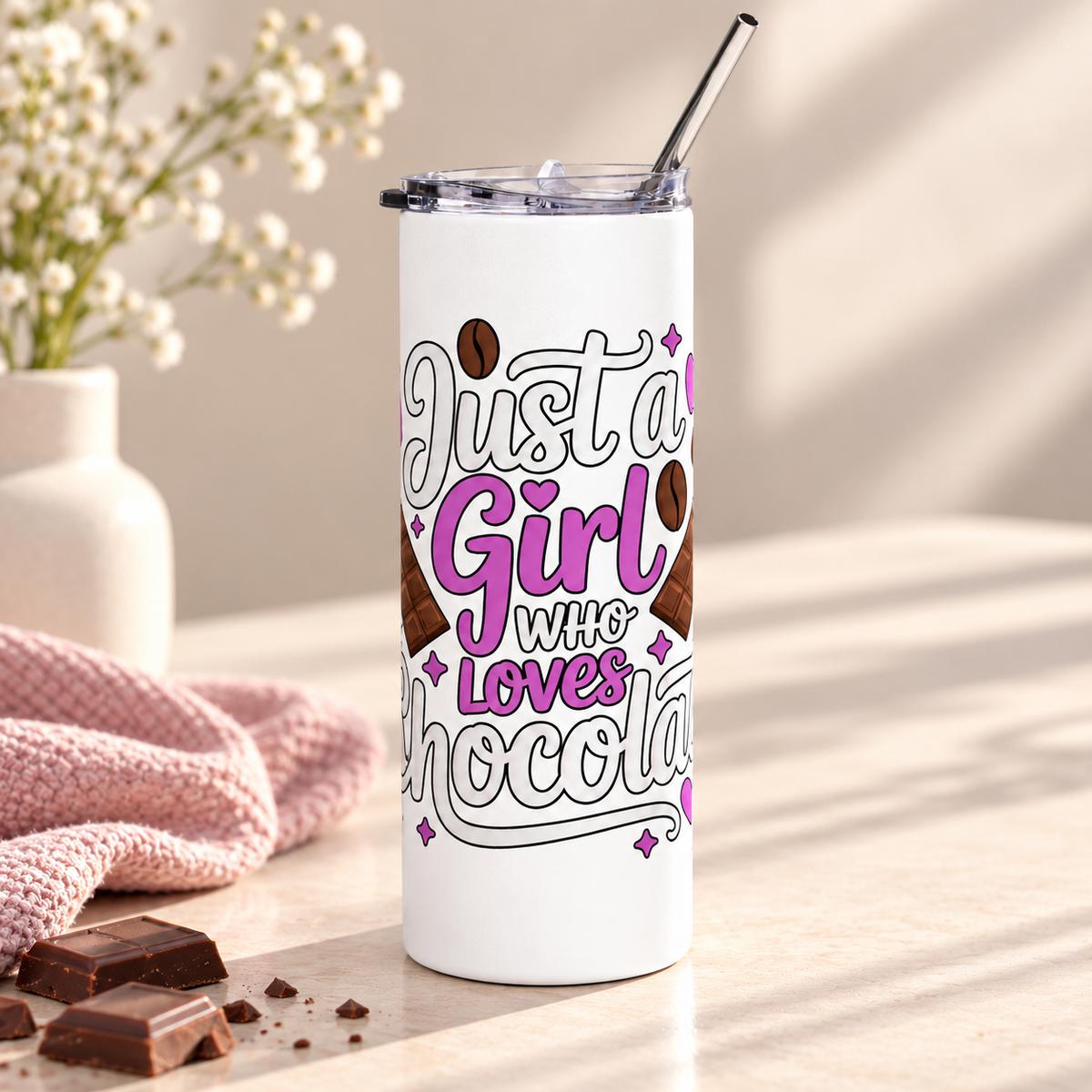 A white stainless steel skinny tumbler with a clear lid and metal straw, printed with "Just a Girl who Loves Chocolate" in white and purple lettering with chocolate bars, cocoa beans and hearts.
