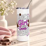 A white stainless steel skinny tumbler with a clear lid and metal straw, printed with "Just a Girl who Loves Chocolate" in white and purple lettering with chocolate bars, cocoa beans and hearts.