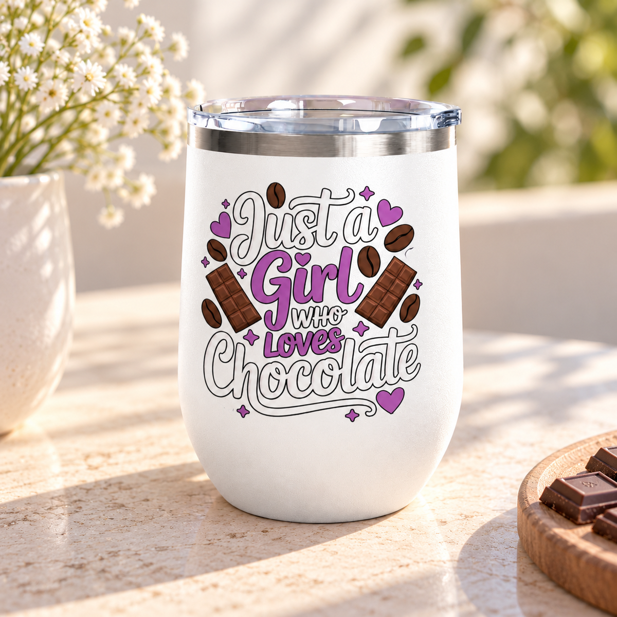 A white stainless steel stemless wine tumbler with a clear push-on lid, printed with "Just a Girl who Loves Chocolate" in white and purple lettering with chocolate bars, cocoa beans and hearts.