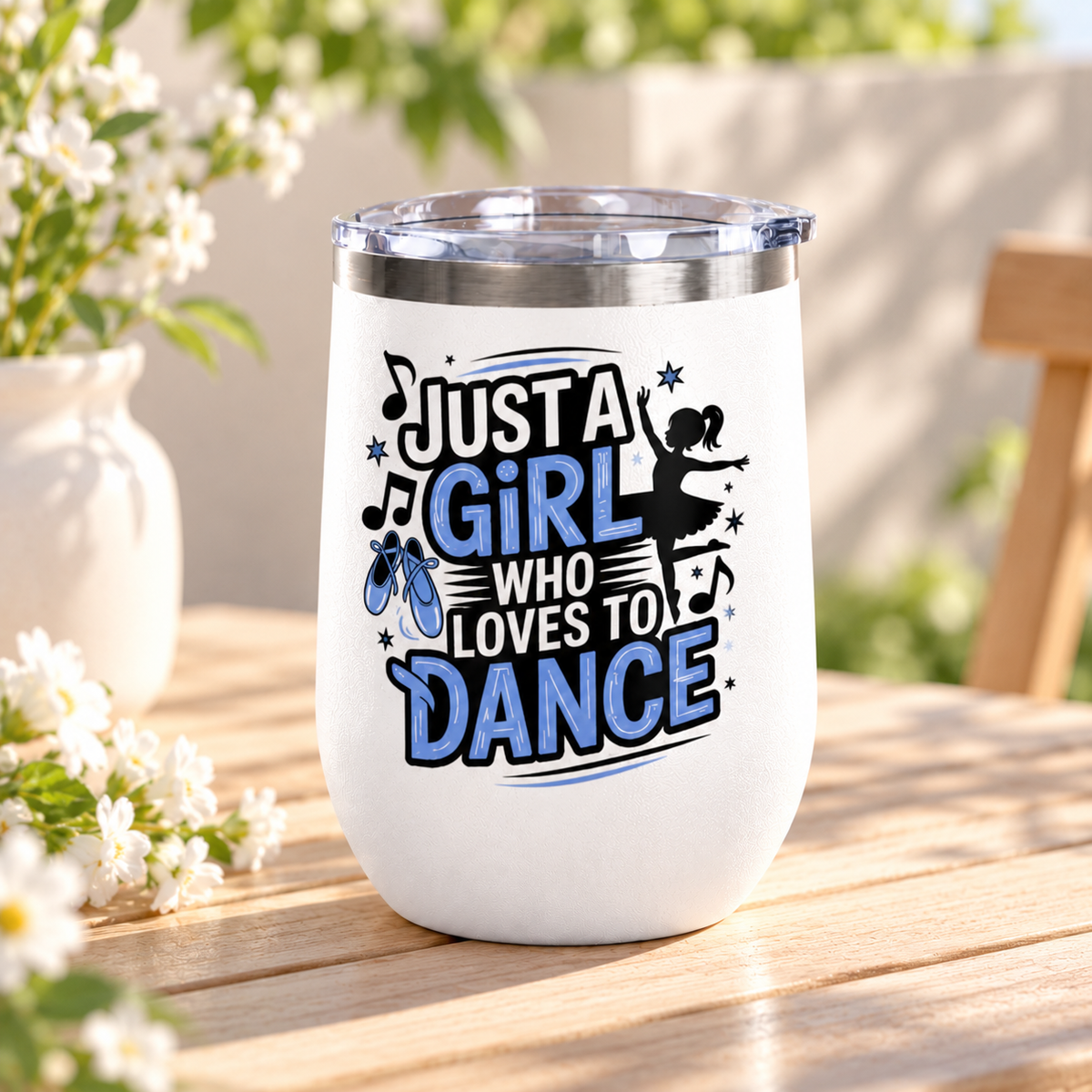 A white stainless steel stemless wine tumbler with a clear push-on lid, printed with "Just a Girl who Loves to Dance" in black and blue lettering with a ballerina silhouette, ballet slippers and music notes.