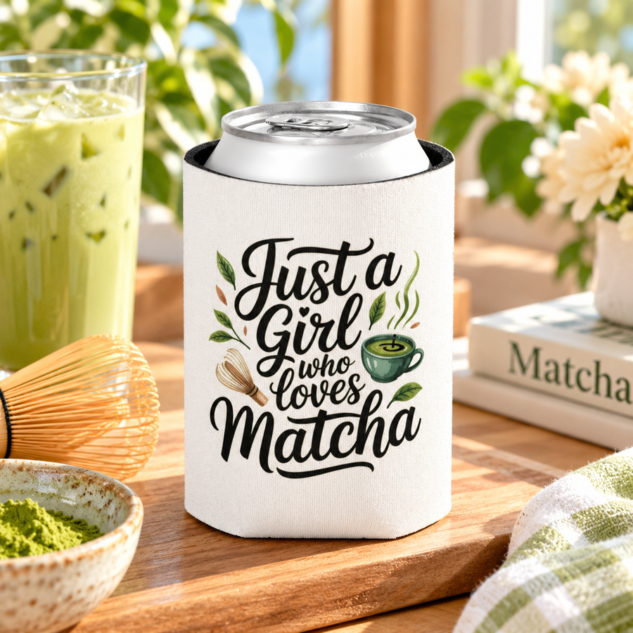 A white can cooler on a drink can, printed with "Just a Girl who Loves Matcha" in black script with a green matcha bowl, a bamboo whisk and tea leaves.