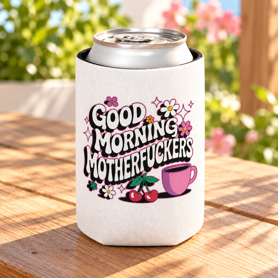 A white can cooler on a drink can, printed with "GOOD MORNING" and a cheeky adult slogan in retro bubble lettering with daisies, cherries, sparkles and a pink coffee cup.