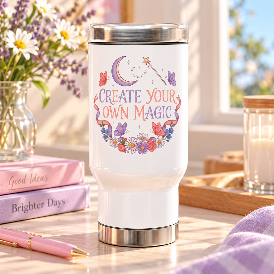 A white stainless steel travel mug with a silver lid and base, printed with "CREATE YOUR OWN MAGIC" in lilac and coral lettering under a crescent moon and a star wand, framed by butterflies, ribbons and flowers.