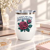A white stainless steel stemless wine tumbler with a clear push-on lid, printed with "MOMMY" in chrome-style block lettering above a large pink rose and rosebud with teal leaves and small sparkles.