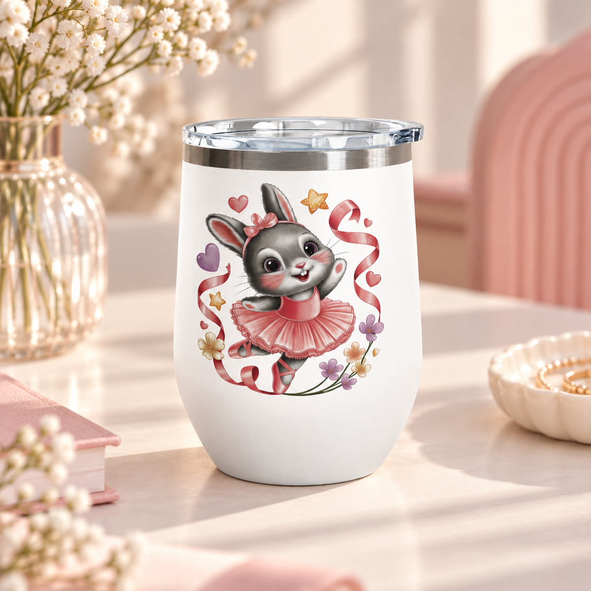 A white stainless steel stemless wine tumbler with a clear push-on lid, printed with a cute gray bunny ballerina in a pink tutu and hair bow, dancing among pink ribbons, hearts, stars and small flowers.