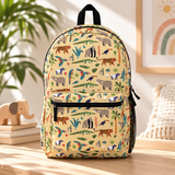 A kids backpack with a black top handle, front zip pocket and mesh side pocket, soft yellow with an all-over print of tigers, elephants, gorillas, crocodiles, tapirs, parrots, toucans and palm leaves.