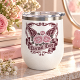 A white stainless steel stemless wine tumbler with a clear push-on lid, printed with pink roses in front of dark burgundy wings, framed by ornate vintage scrollwork, above a banner reading "Eternal Love".