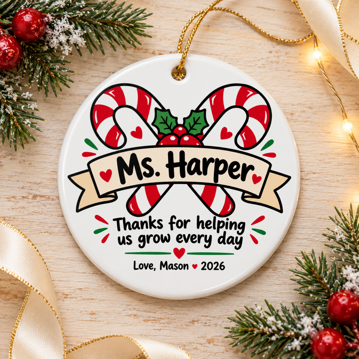 A round white ceramic Christmas ornament on a gold string, printed with two crossed red and white candy canes with holly and berries behind a banner with a sample teacher name, "Thanks for helping us grow every day", hearts and a "Love" signature with "2026".