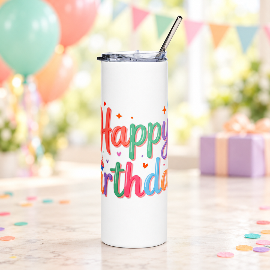 A white stainless steel skinny tumbler with a clear lid and metal straw, printed with "Happy Birthday!" in rainbow pastel lettering with bunches of balloons, a cupcake and small hearts.