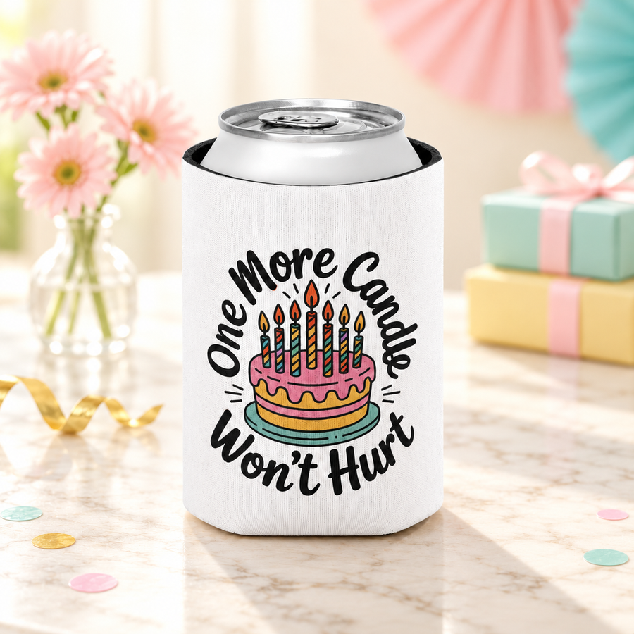 A white can cooler on a drink can, printed with "One More Candle Won't Hurt" in black script around a pink and yellow birthday cake with striped lit candles.
