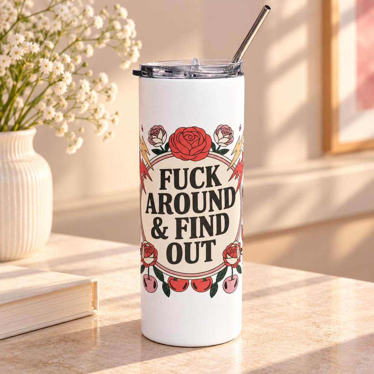 A white stainless steel skinny tumbler with a clear lid and metal straw, printed with a cheeky adult slogan ending "& FIND OUT" in bold black lettering on a cream circle, ringed by red roses, lightning bolts, flames and cherries.